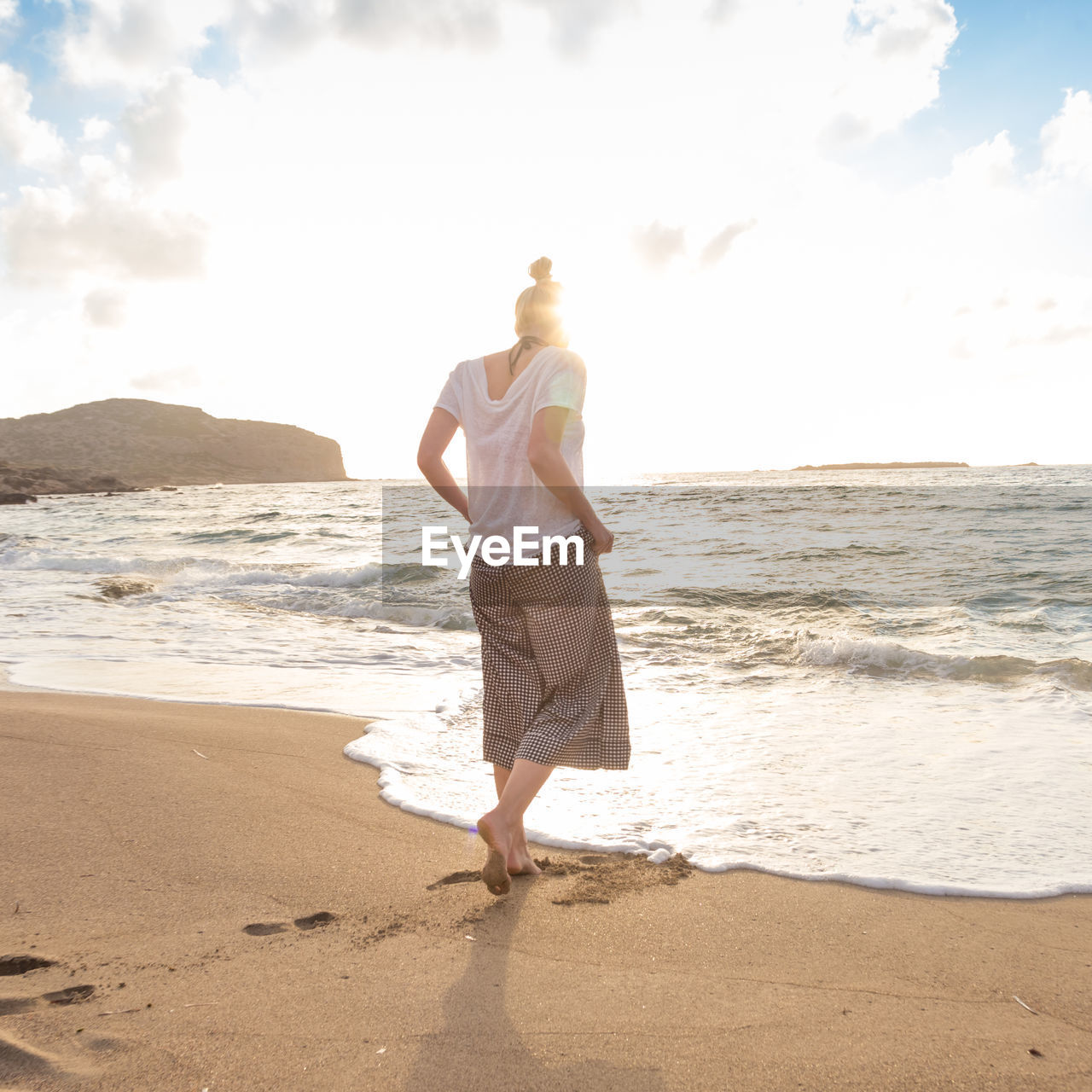 REAR VIEW OF MAN STANDING ON BEACH