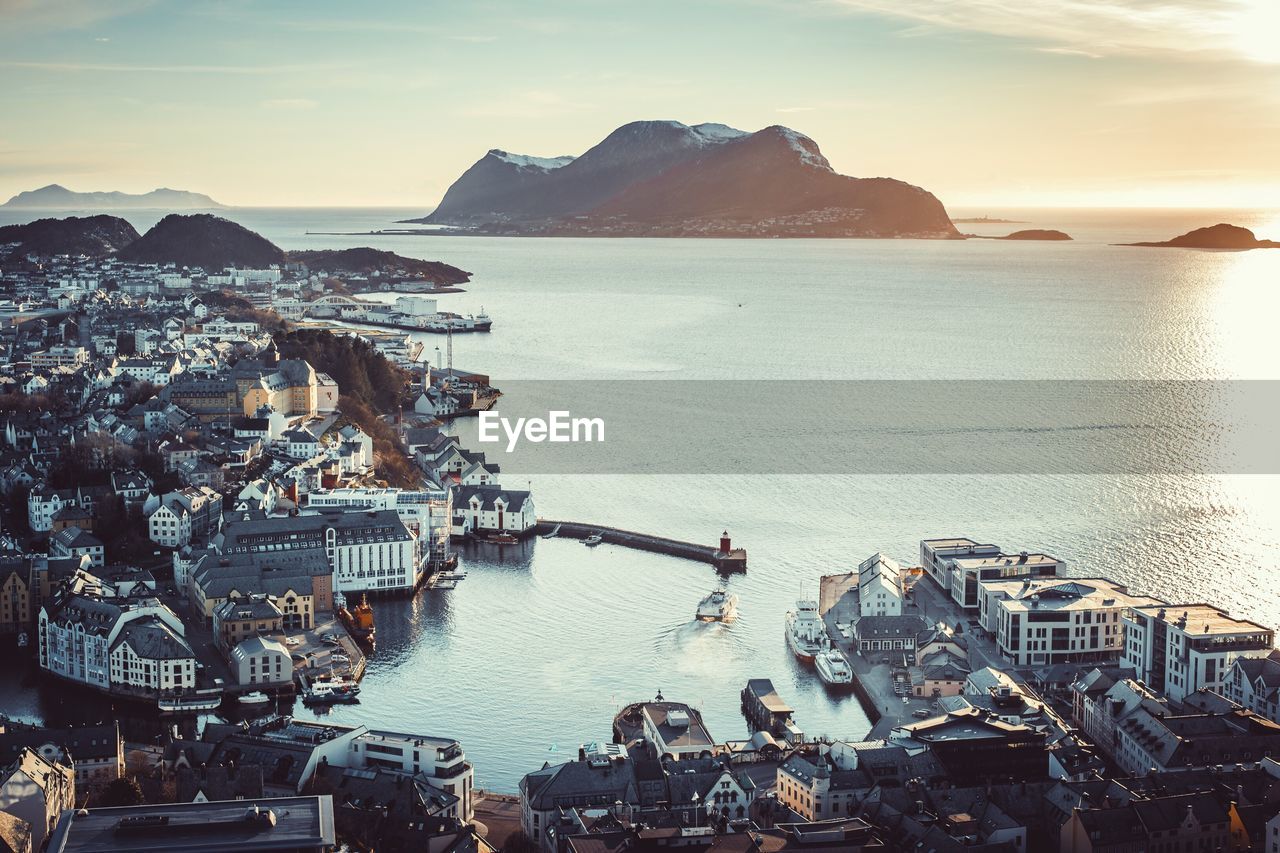 High angle view of city by sea against sky