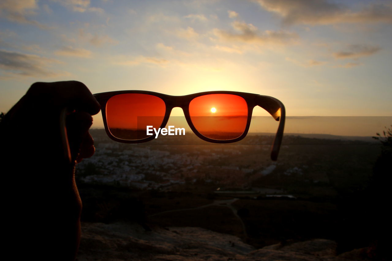 CLOSE-UP OF MID ADULT MAN AGAINST SUNSET SKY