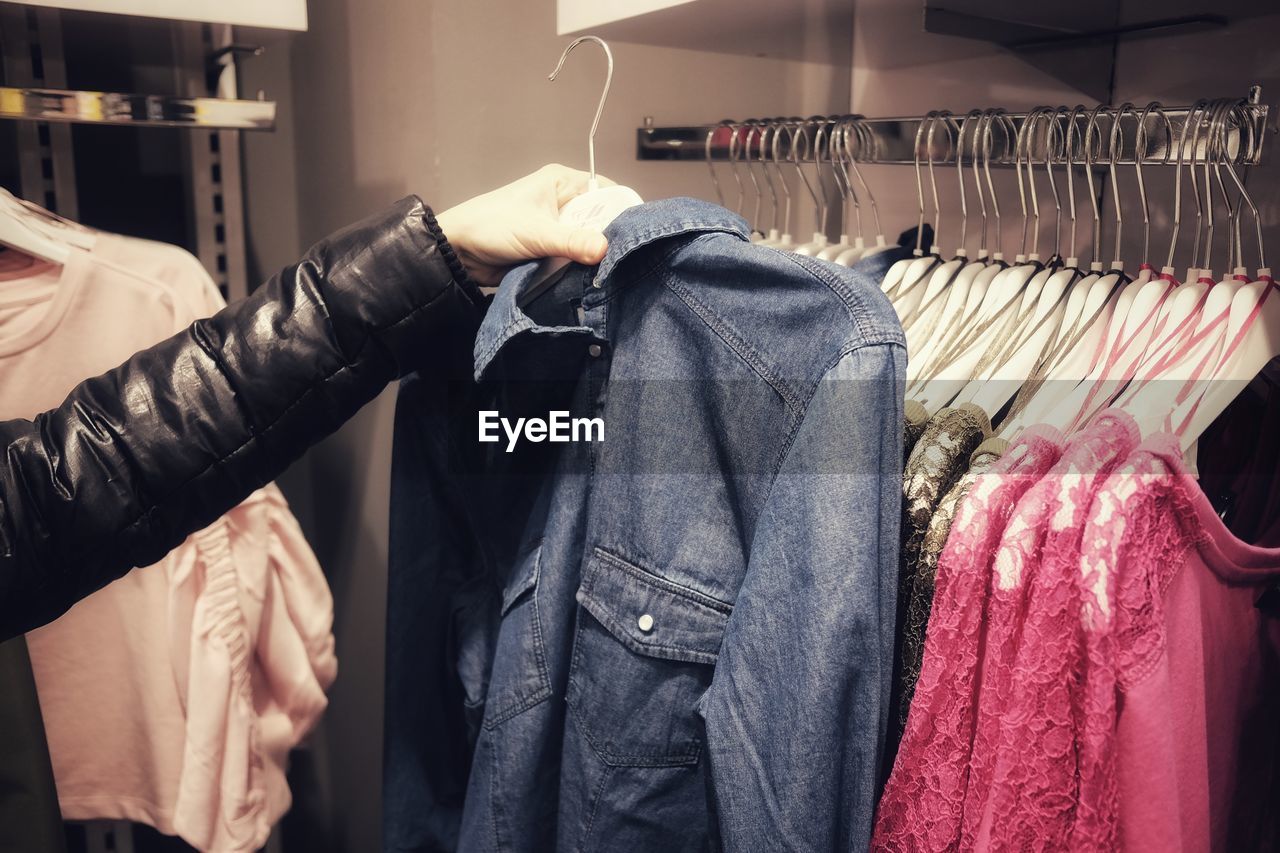 Close-up of woman buying clothes at shop