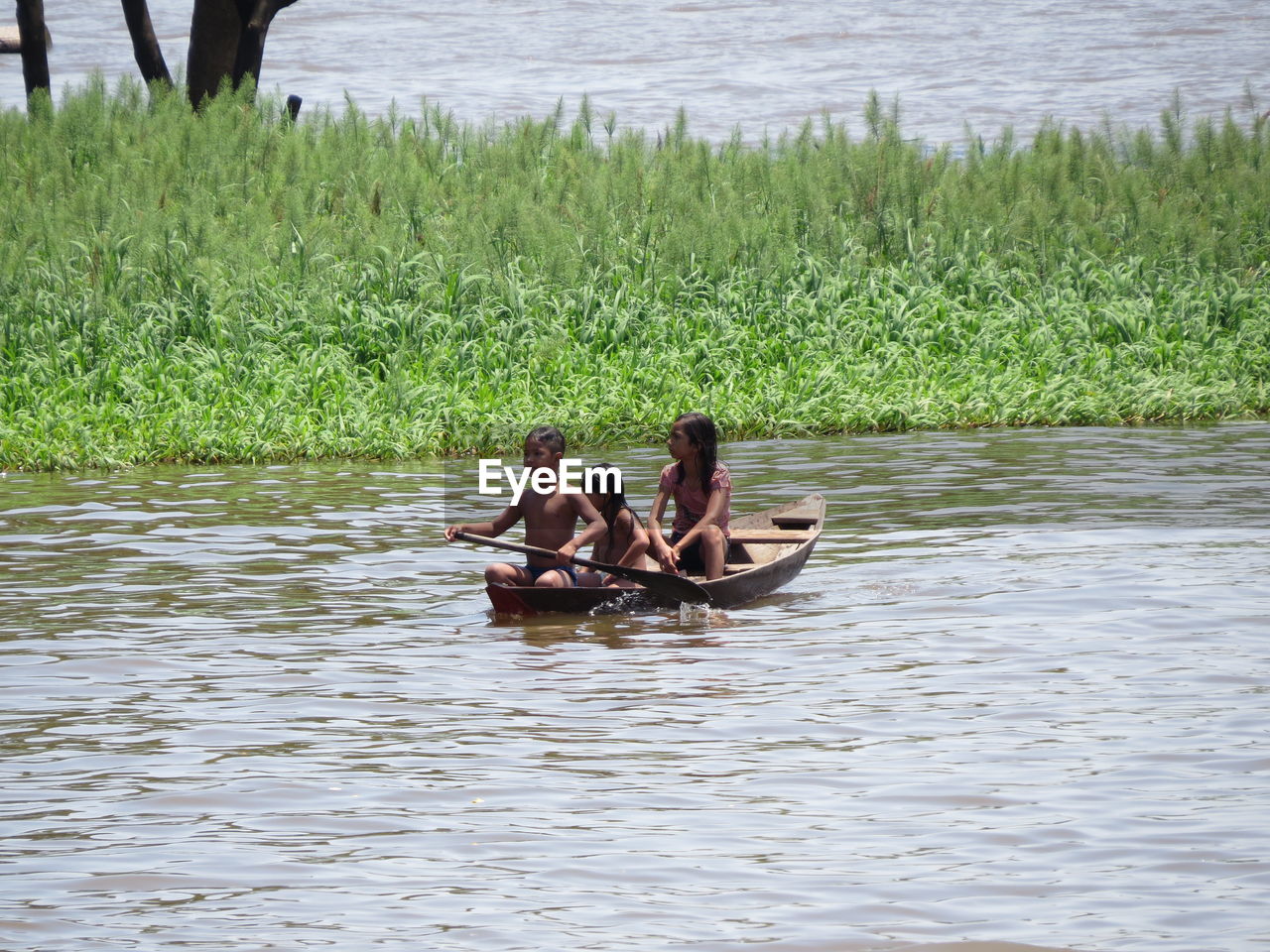 MAN SITTING ON BENCH IN RIVER