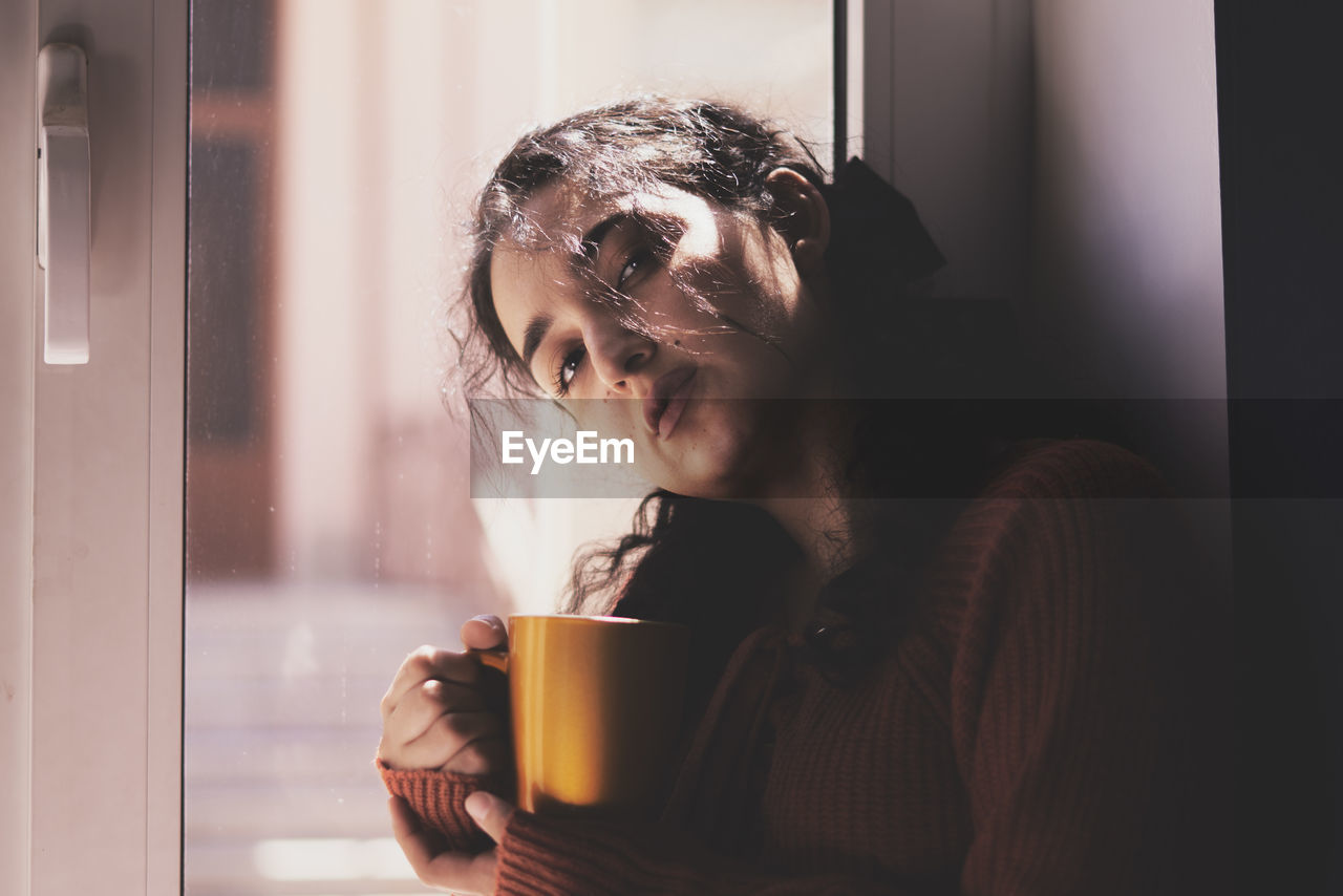 Young woman drinking coffee cup at home