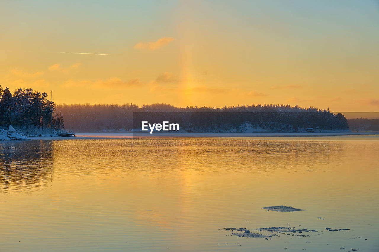 Scenic view of lake against orange sky