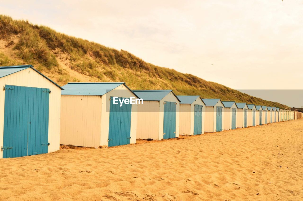 Beach huts by sea against sky