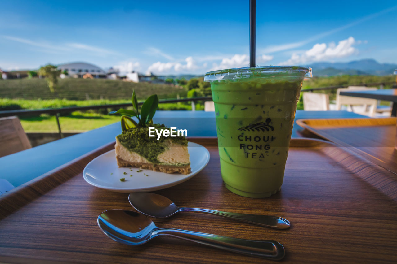 CLOSE-UP OF DRINK IN GLASS ON TABLE AGAINST SKY