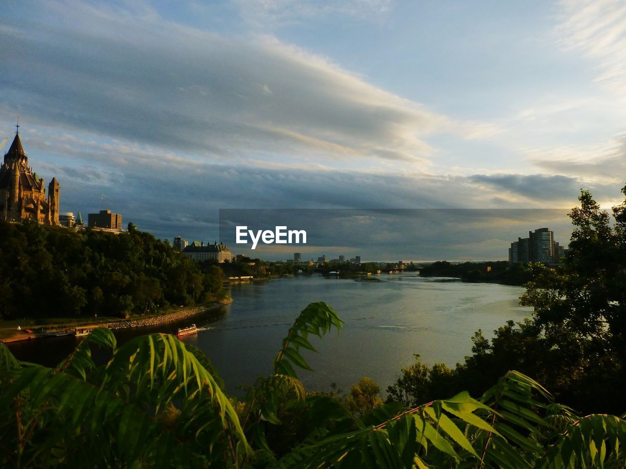 SCENIC VIEW OF RIVER AMIDST BUILDINGS AGAINST SKY