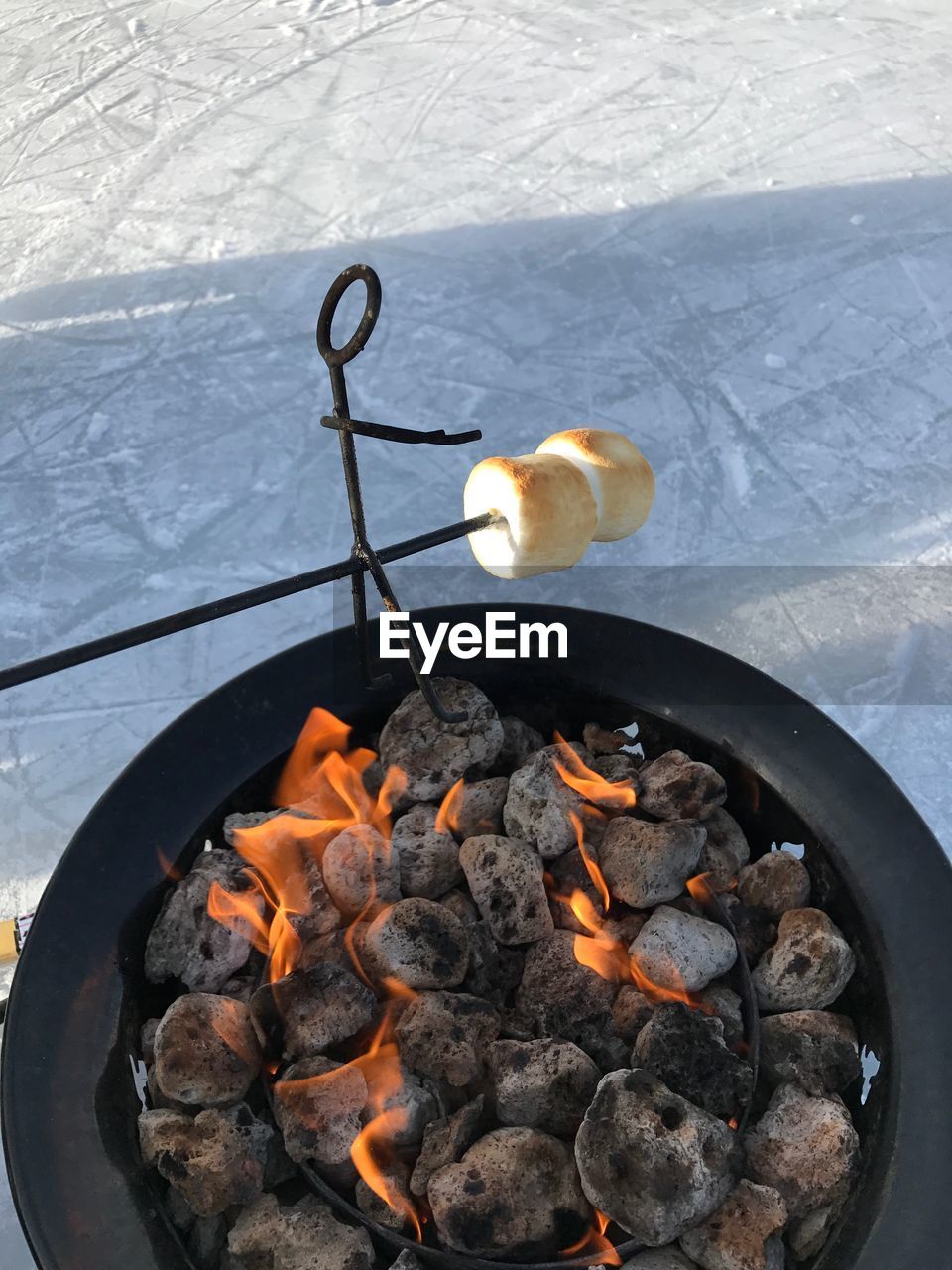 High angle view of marshmallow over fire pit