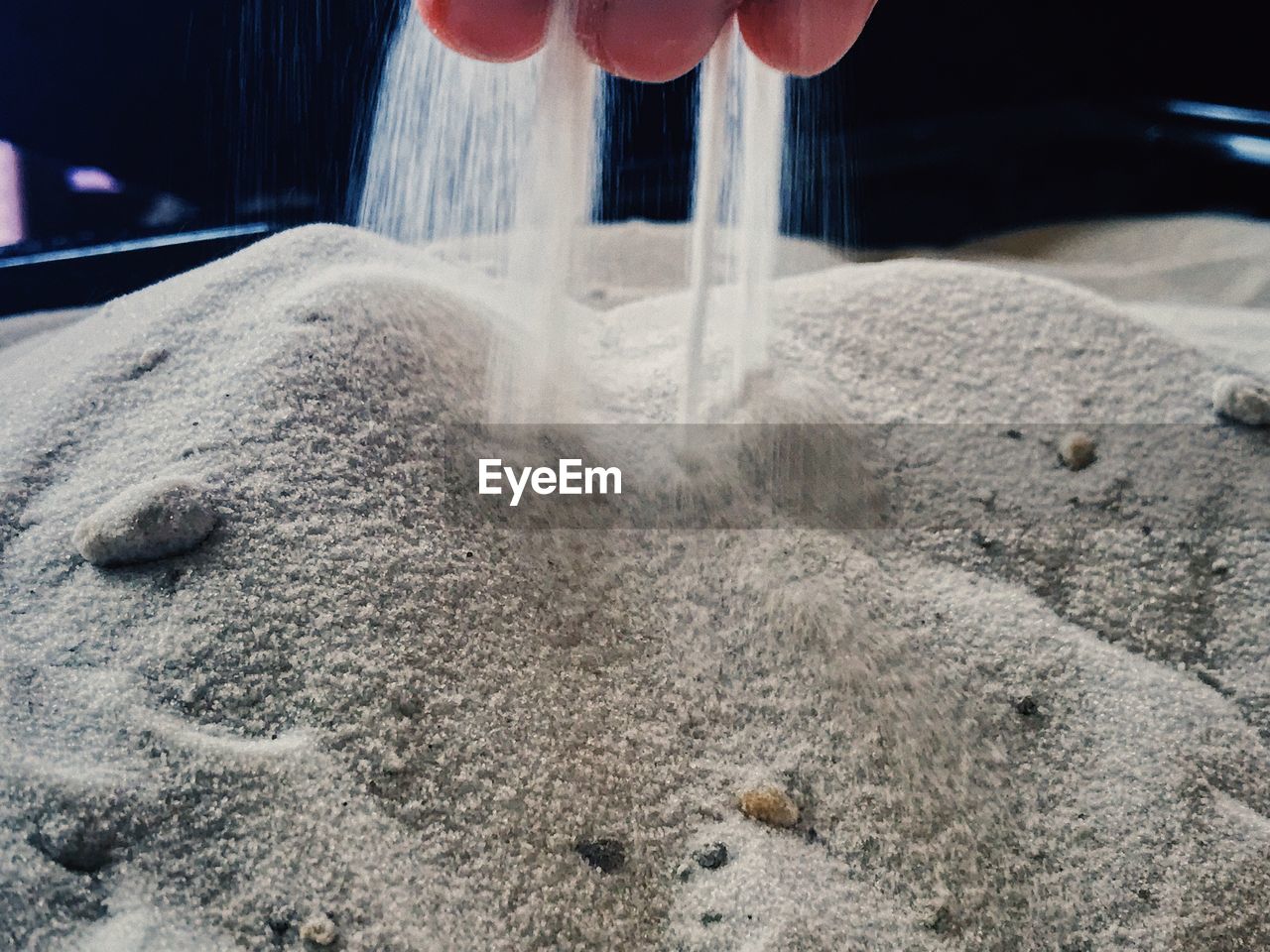 Cropped hand playing with sand at beach