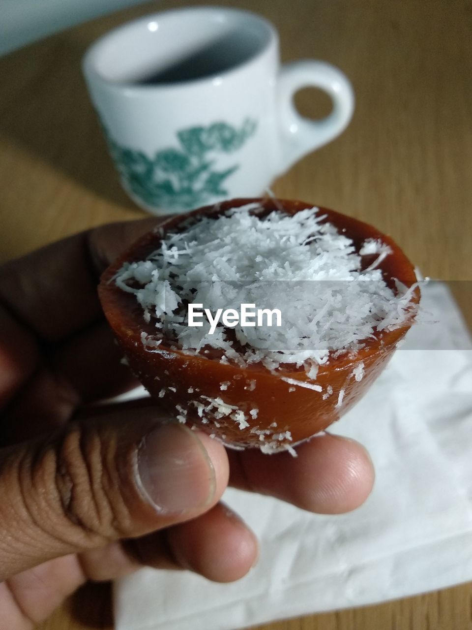 CLOSE-UP OF HAND HOLDING ICE CREAM WITH SPOON