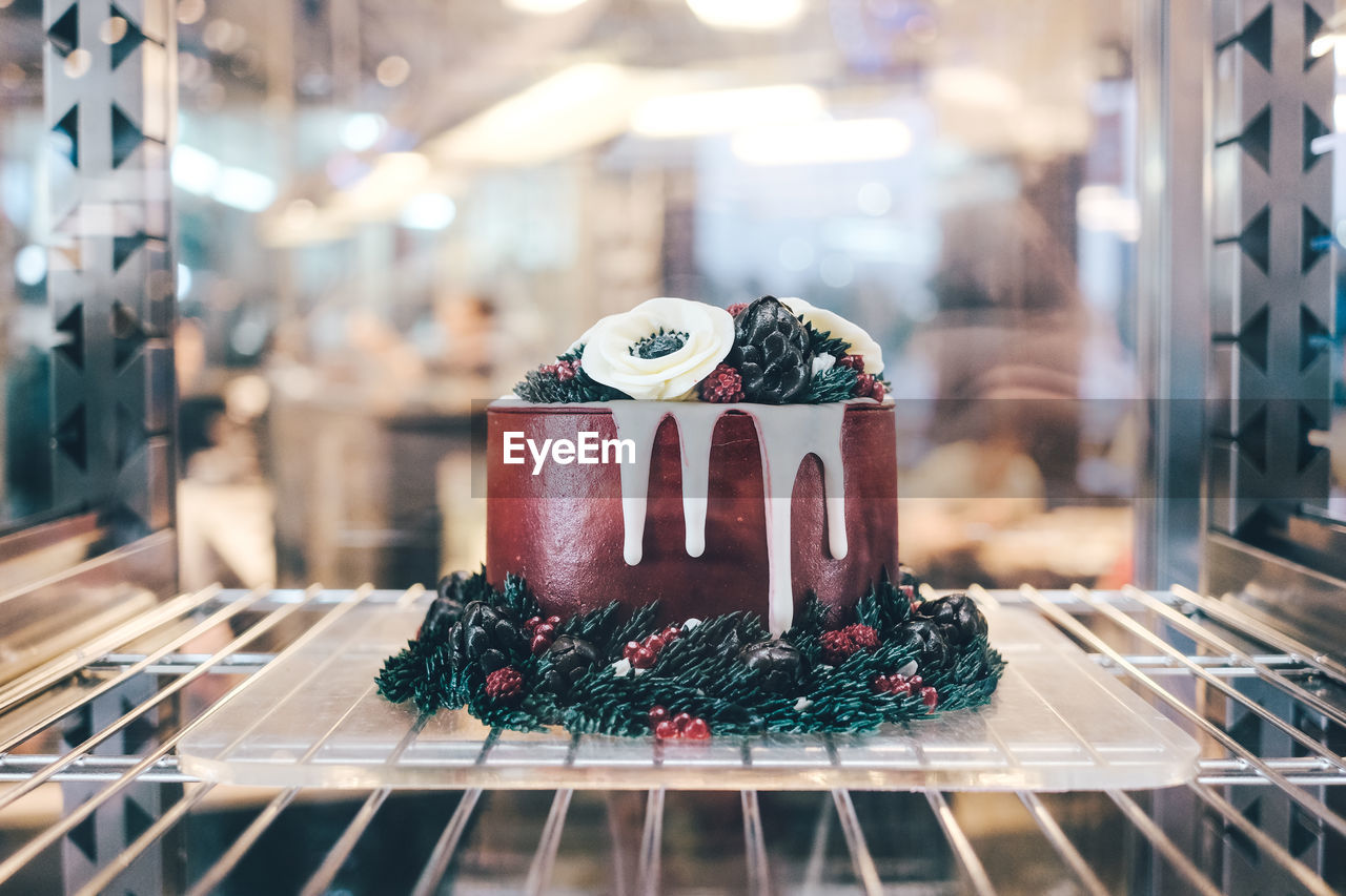 CLOSE-UP OF CAKE ON TABLE AGAINST CHRISTMAS LIGHTS