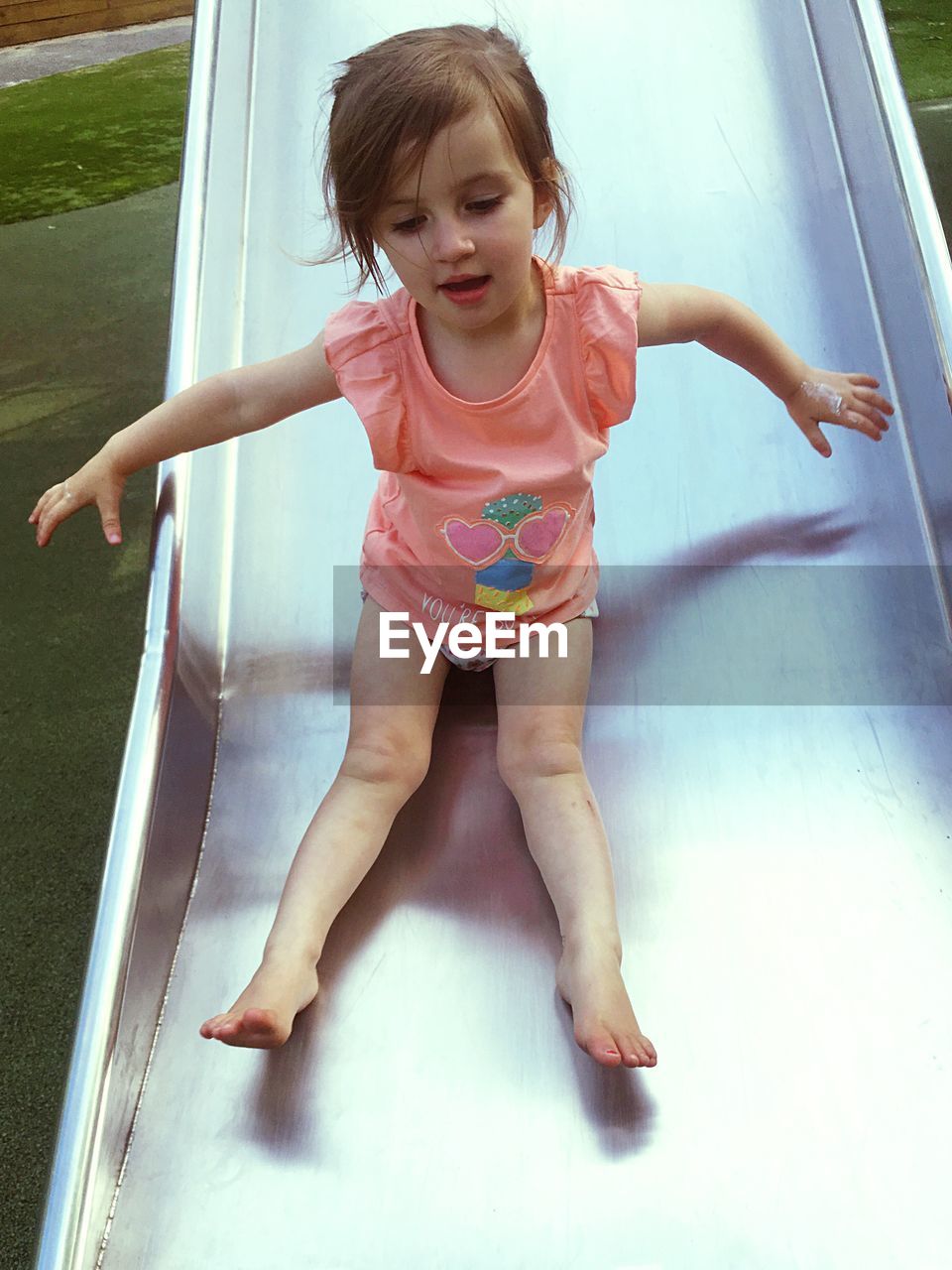 Full length of girl enjoying on slide at park