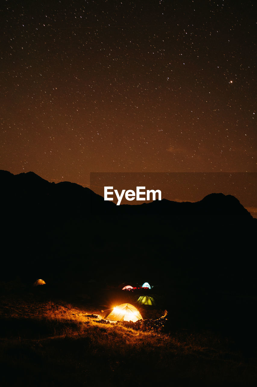 scenic view of mountains against star field at night