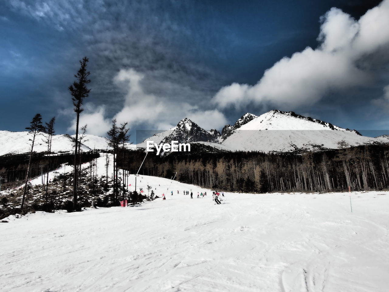 Scenic view of snow covered mountains against cloudy sky