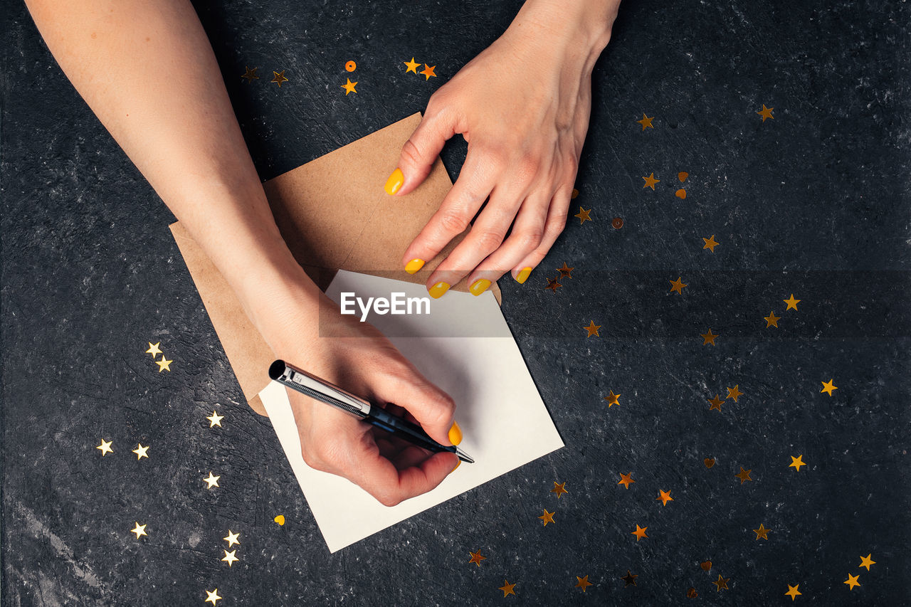 A woman writes plans for 2022 on black background top view