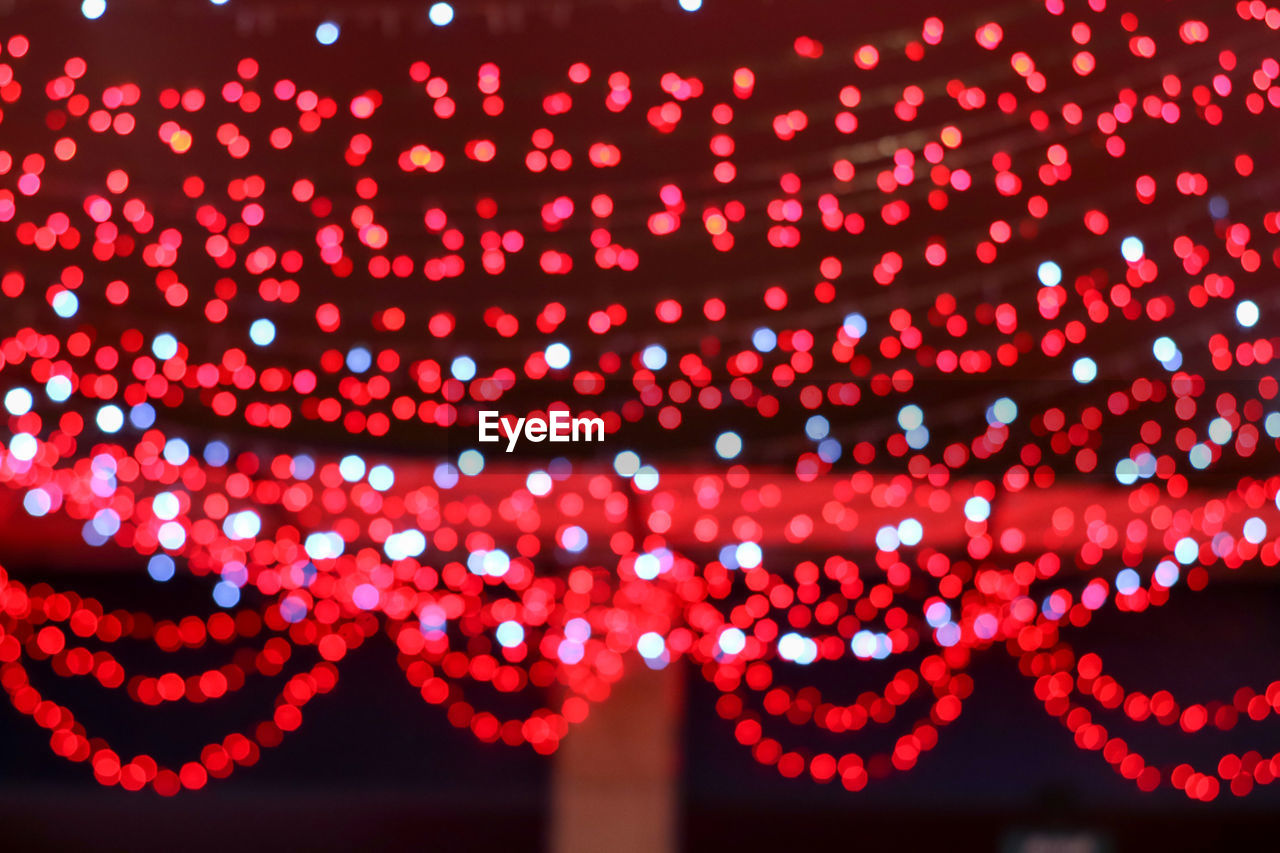 Defocused image of illuminated lights hanging at night