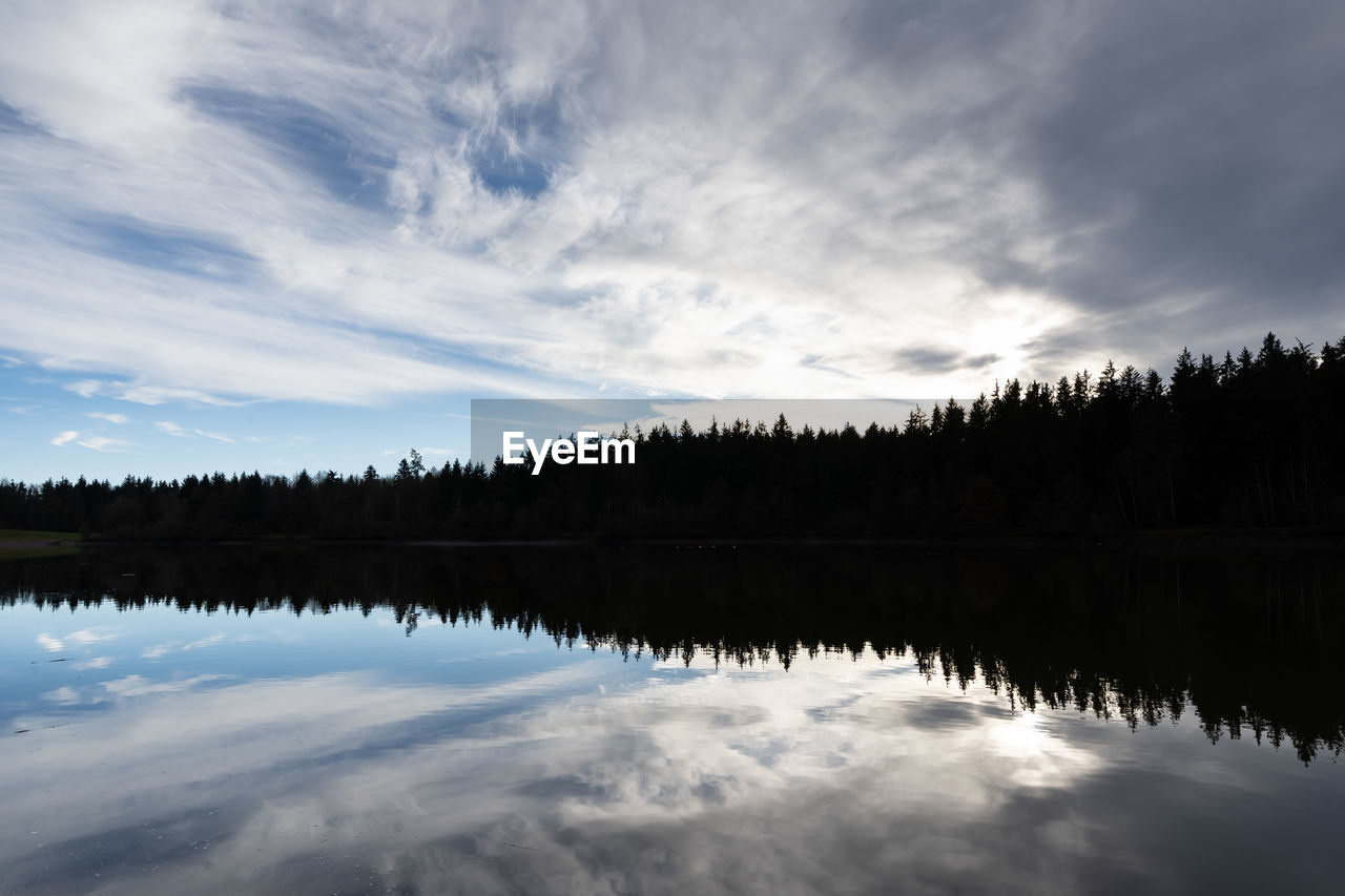 reflection, water, sky, cloud, nature, lake, scenics - nature, tranquility, beauty in nature, tree, tranquil scene, morning, dawn, body of water, mountain, plant, no people, forest, sunlight, environment, landscape, non-urban scene, horizon, idyllic, outdoors, winter, woodland, coniferous tree, land, pine tree, reflection lake, blue