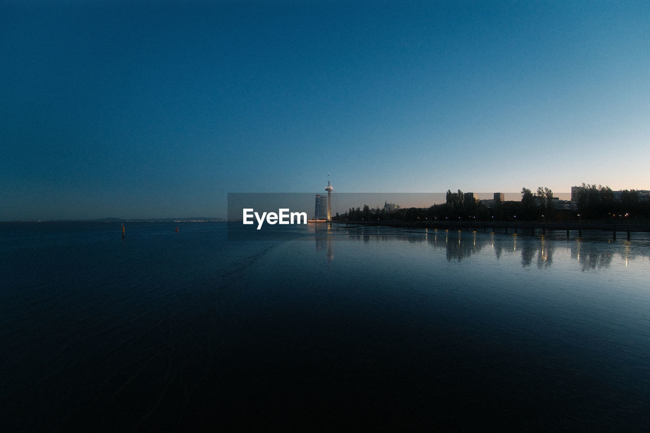 Torre vasco da gama tower after sunset, blue hour, river, ocean, clear sky, lisbon