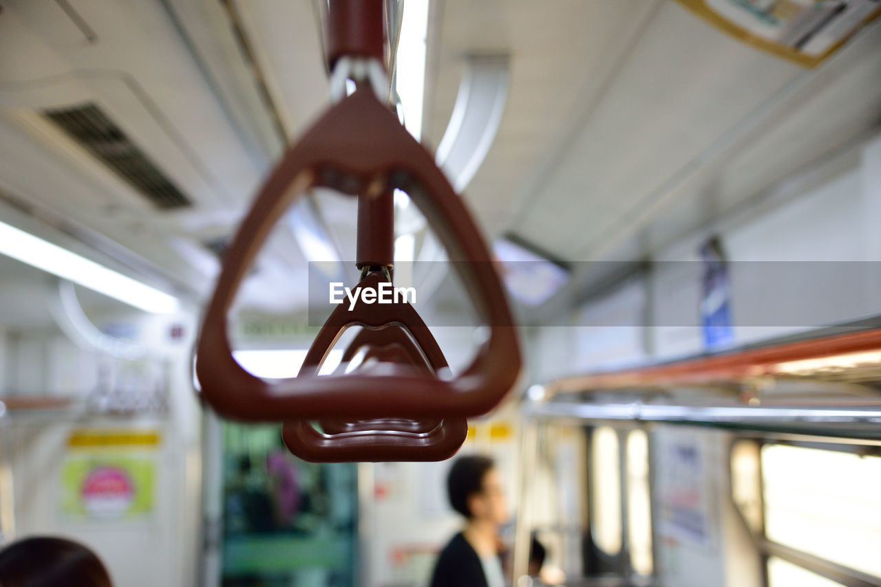 Close-up of handles hanging in train