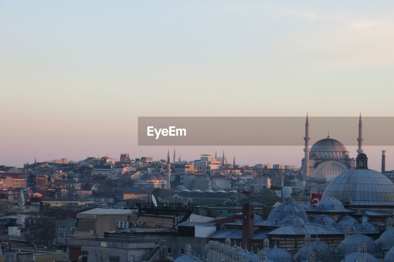 View of buildings in city against sky at sunset