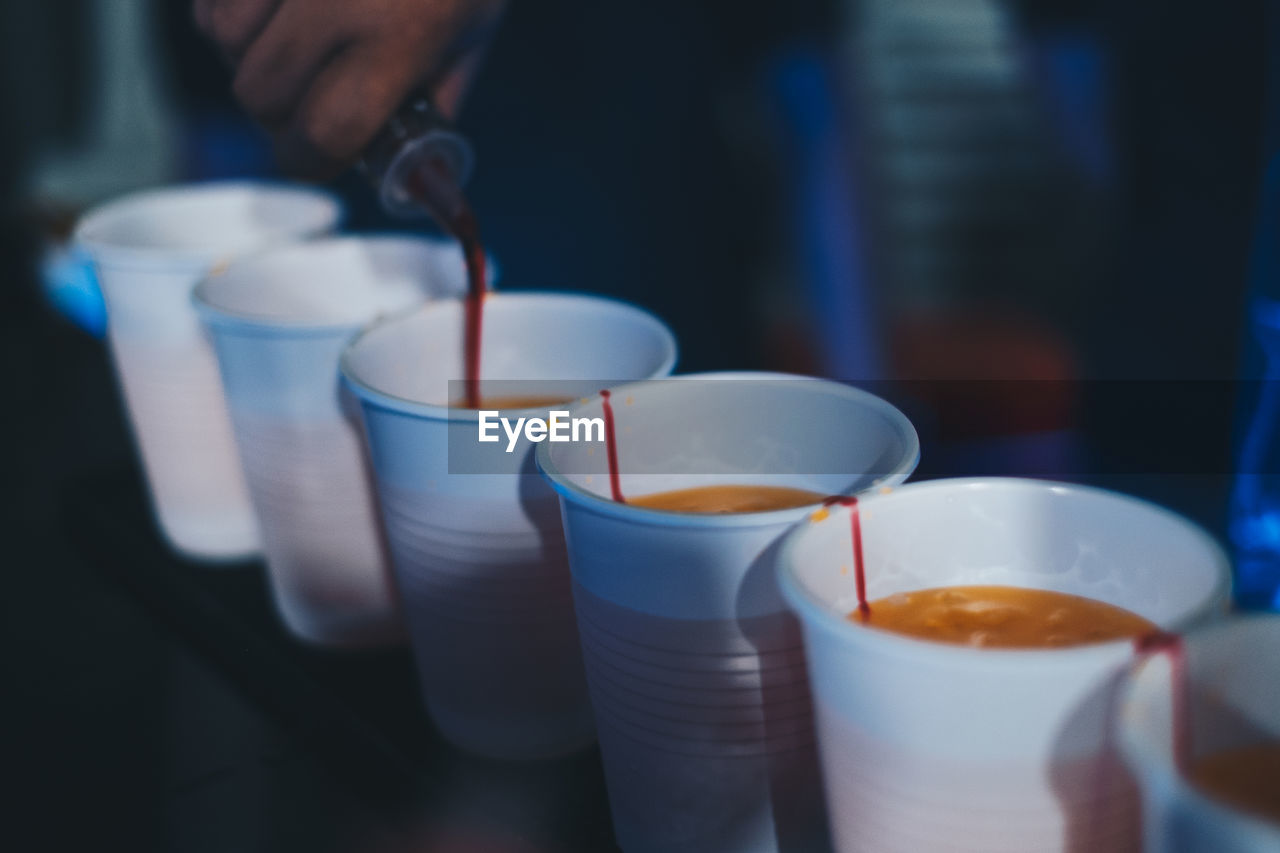 food and drink, drink, refreshment, cup, blue, indoors, close-up, holding, hand, food, mug, one person, focus on foreground, coffee cup, coffee, business, household equipment, selective focus, adult, meal, pouring, glass, freshness, drinking glass, milk, hot drink, table, dairy, restaurant, cafe