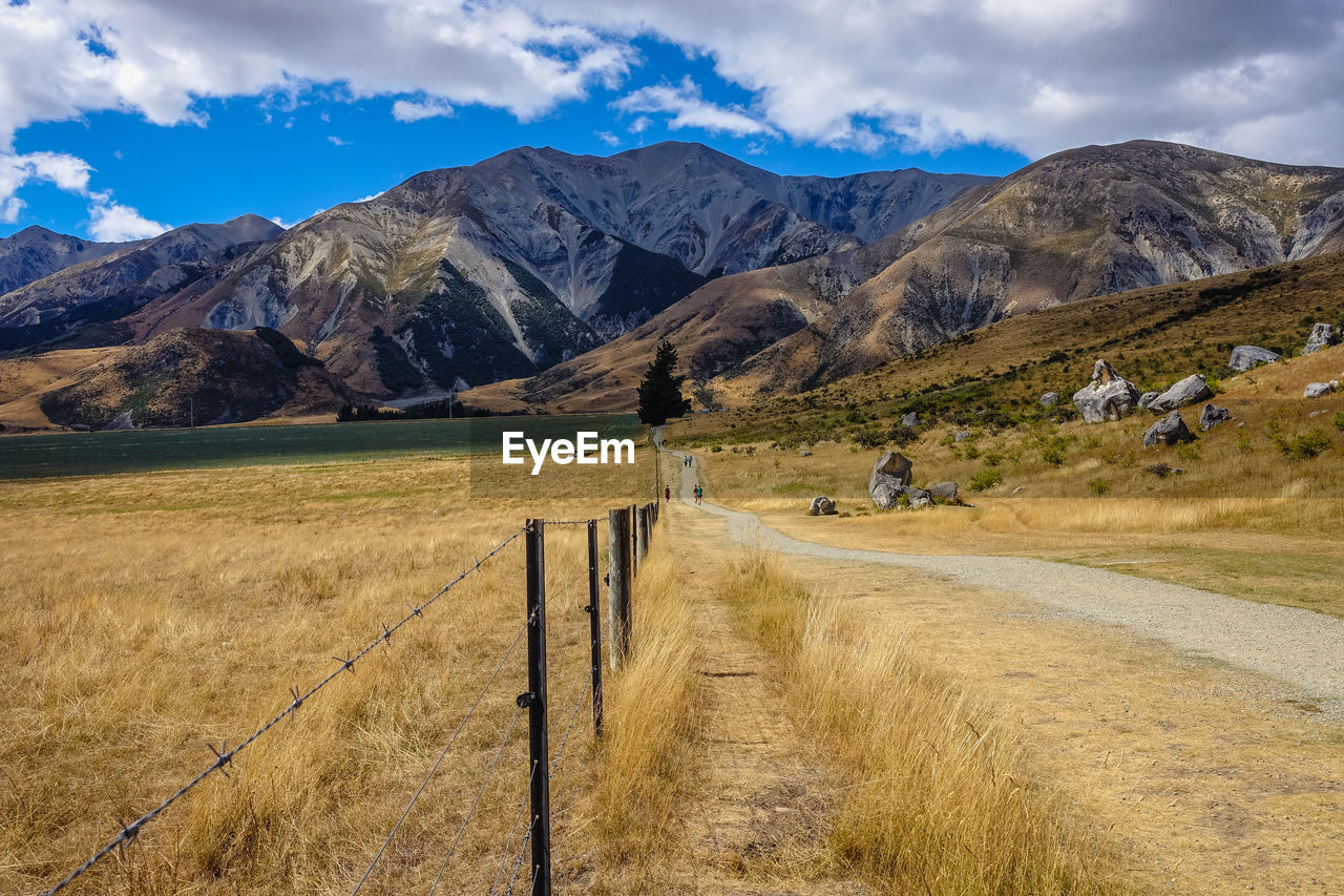 Scenic view of field and mountains against sky