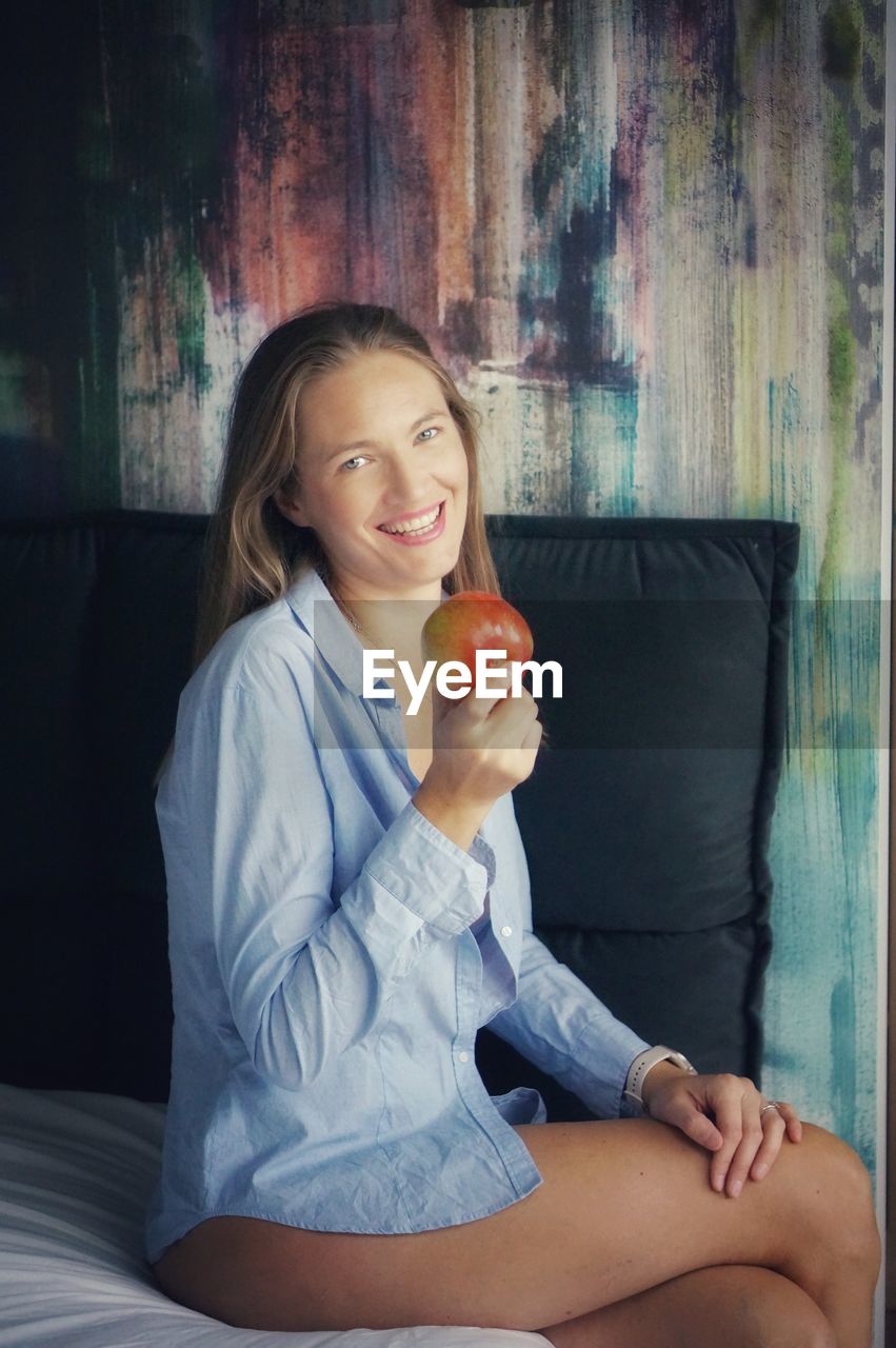 portrait of young woman eating apple