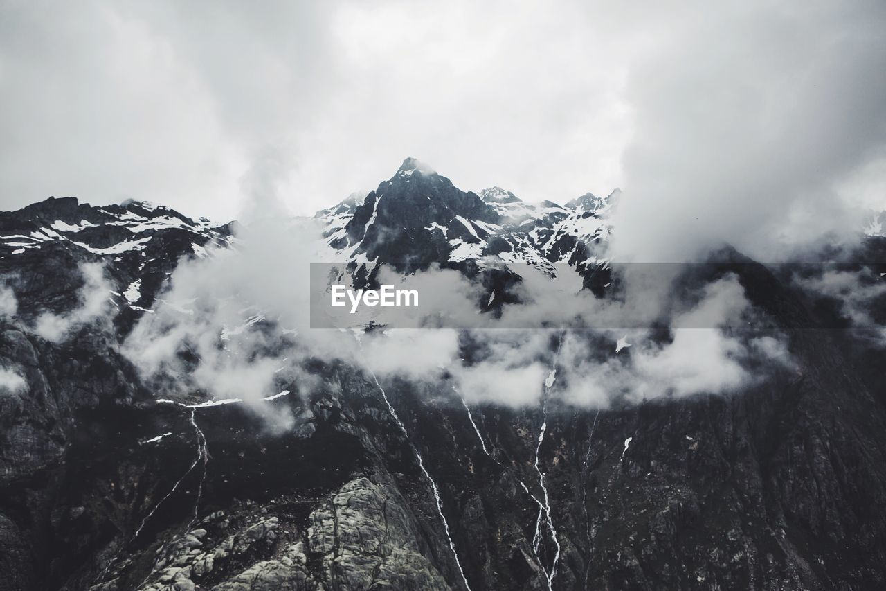 Low angle view of snow covered mountain against sky