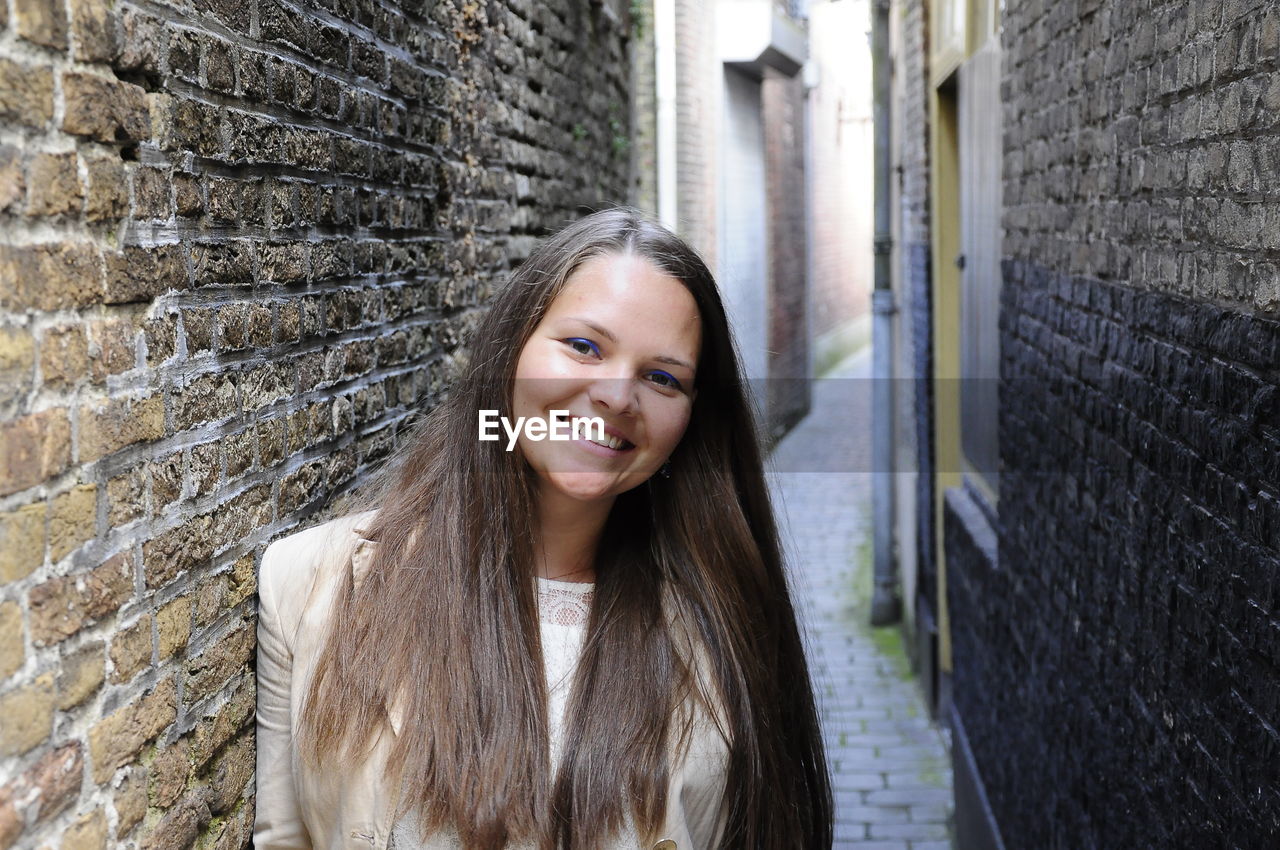 PORTRAIT OF YOUNG WOMAN IN TRADITIONAL BUILDING