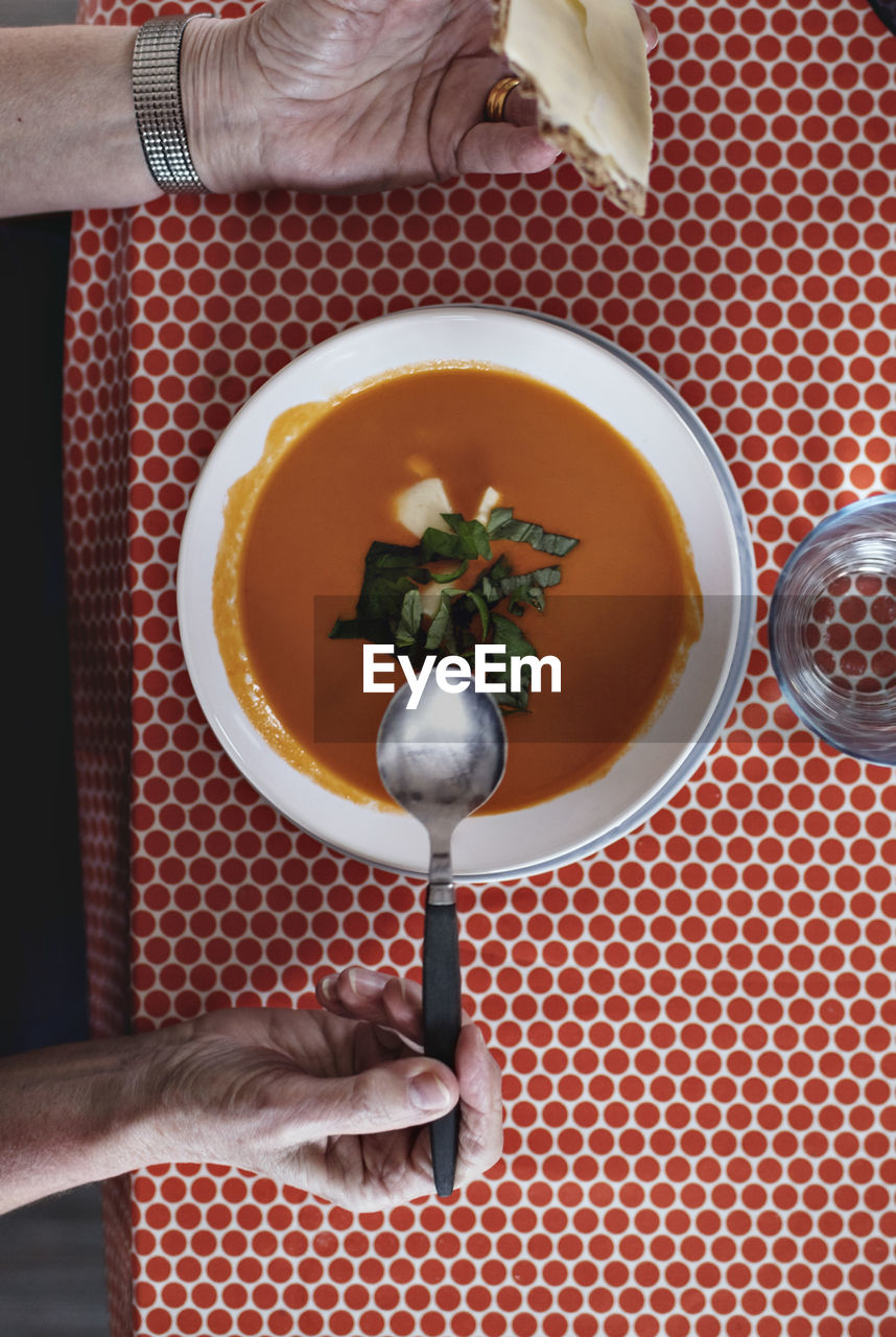 Directly above view of senior man eating fresh soup at dining table