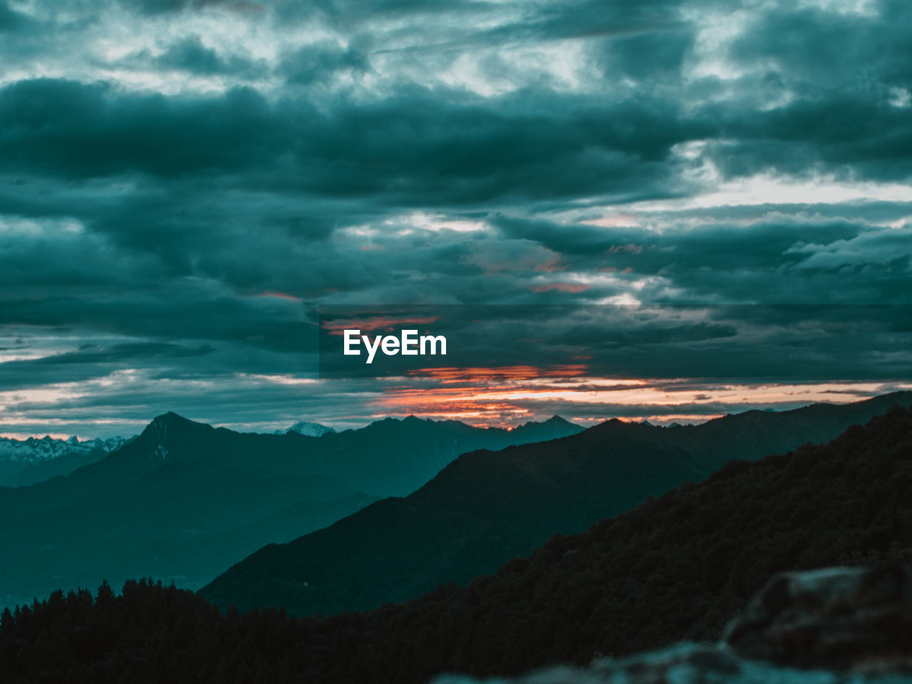 SCENIC VIEW OF MOUNTAIN AGAINST DRAMATIC SKY