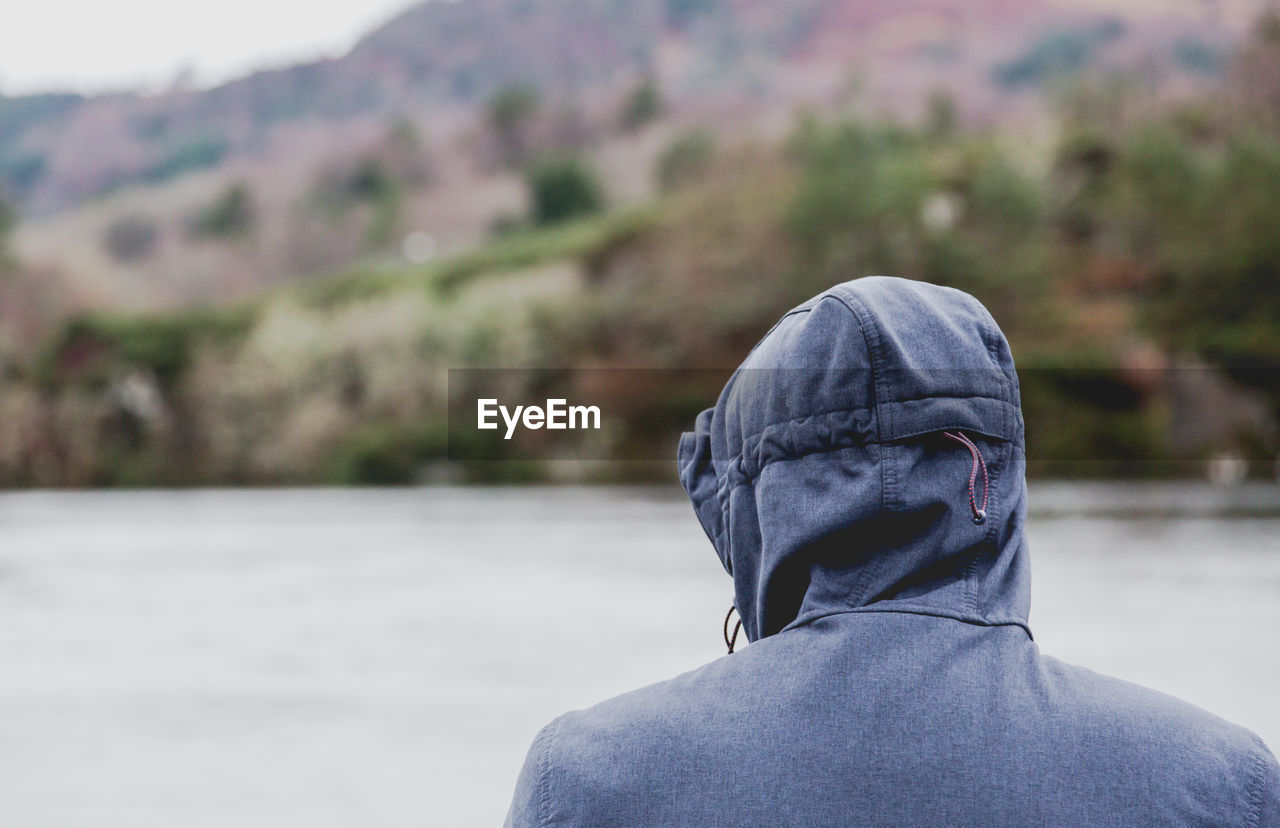 Rear view of man against lake