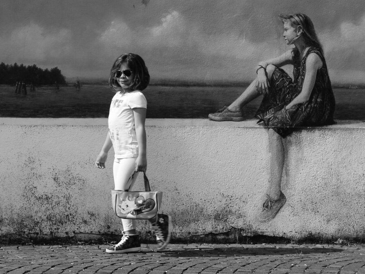 Full length portrait of girl walking against mural