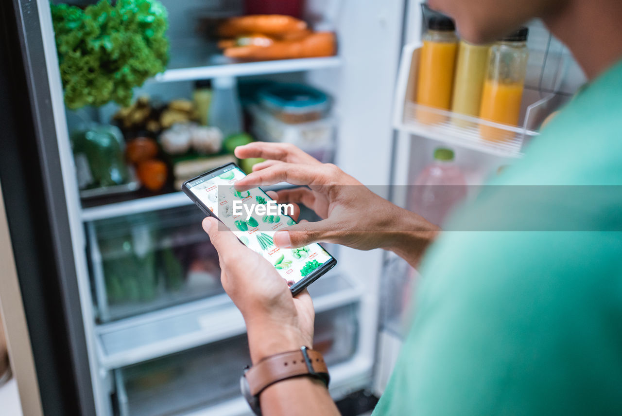 Midsection of woman holding camera at store