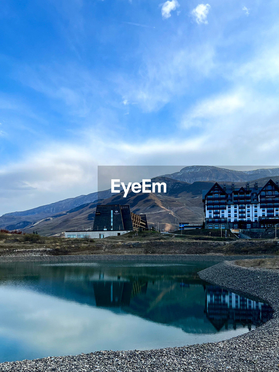 scenic view of lake and buildings against sky