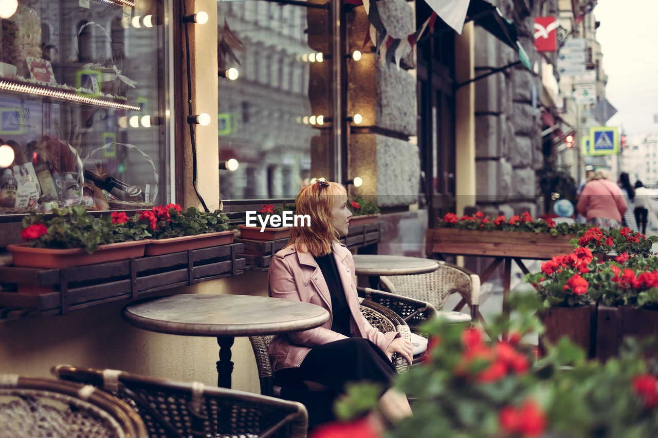 Woman sitting at sidewalk cafe