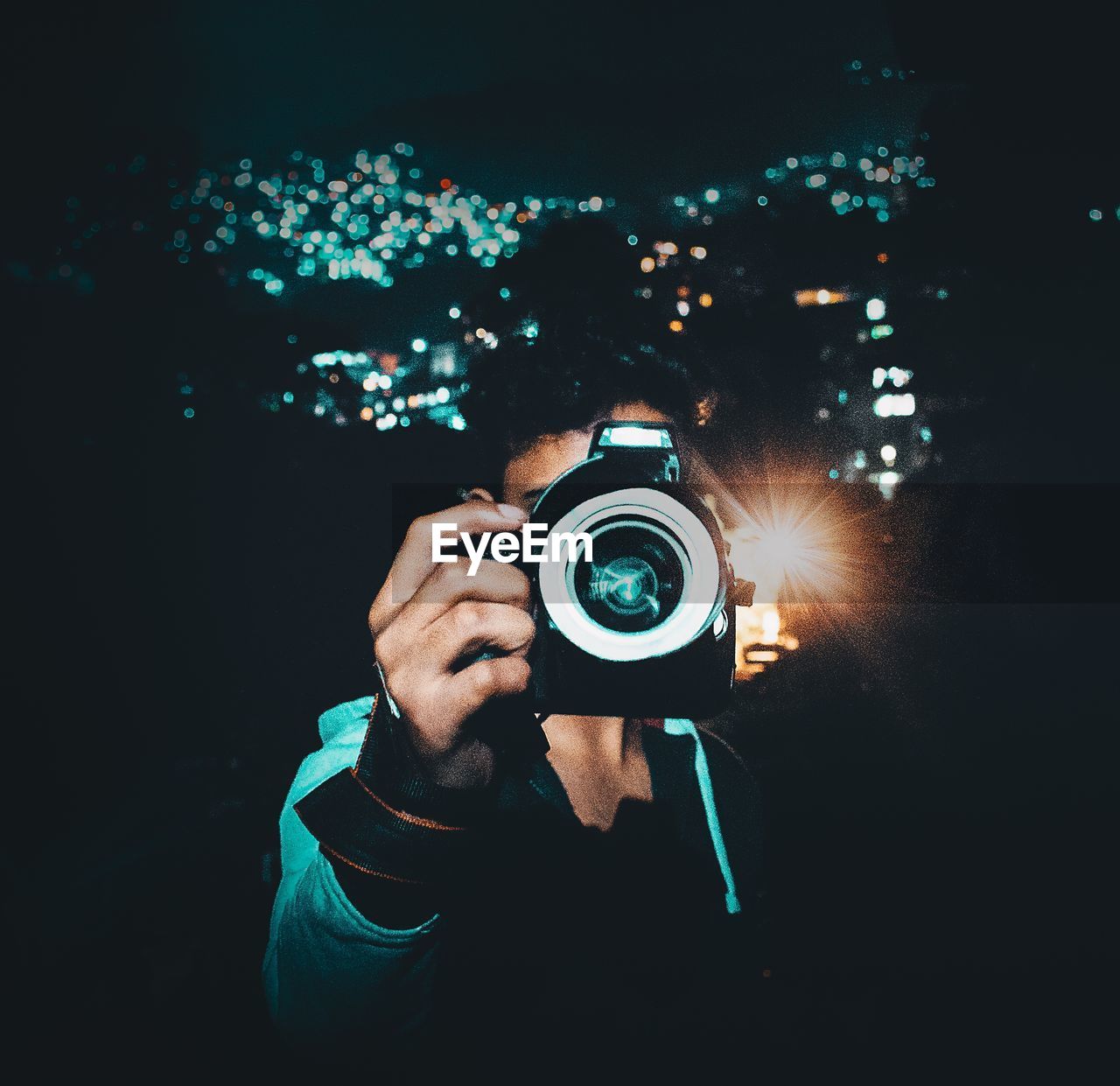 Man photographing through digital camera at night