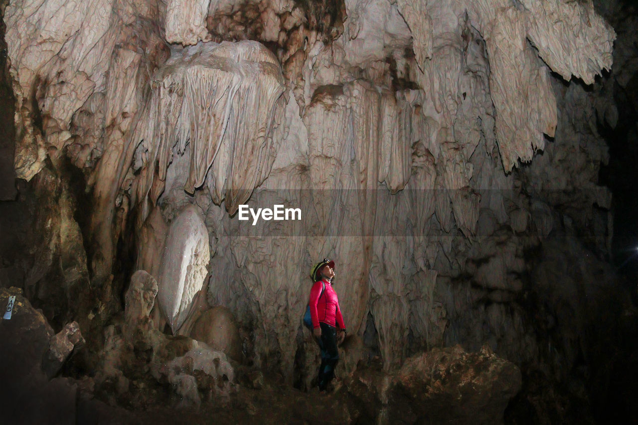 Woman standing on rock in cave