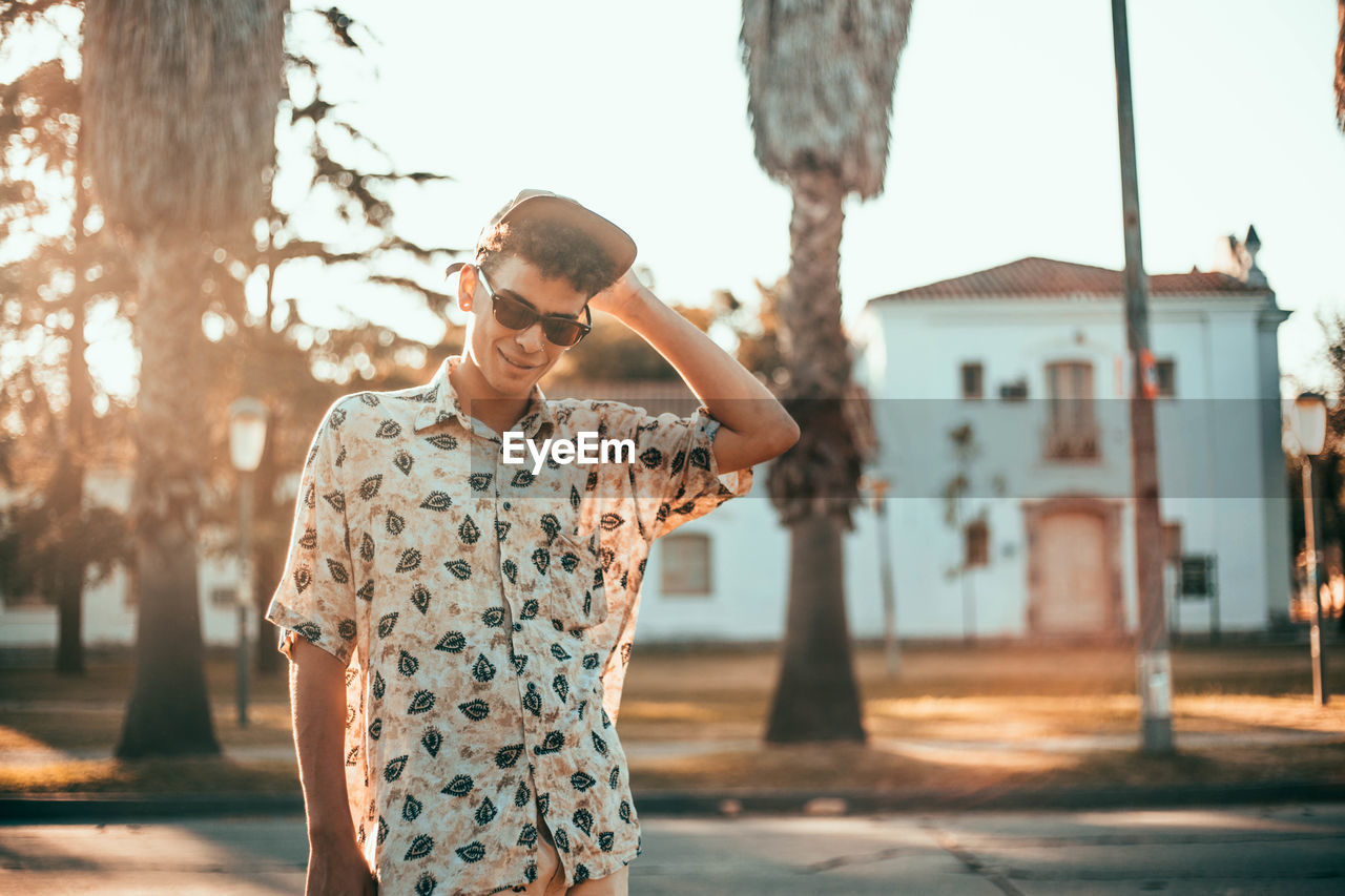 Man in sunglasses standing against sky