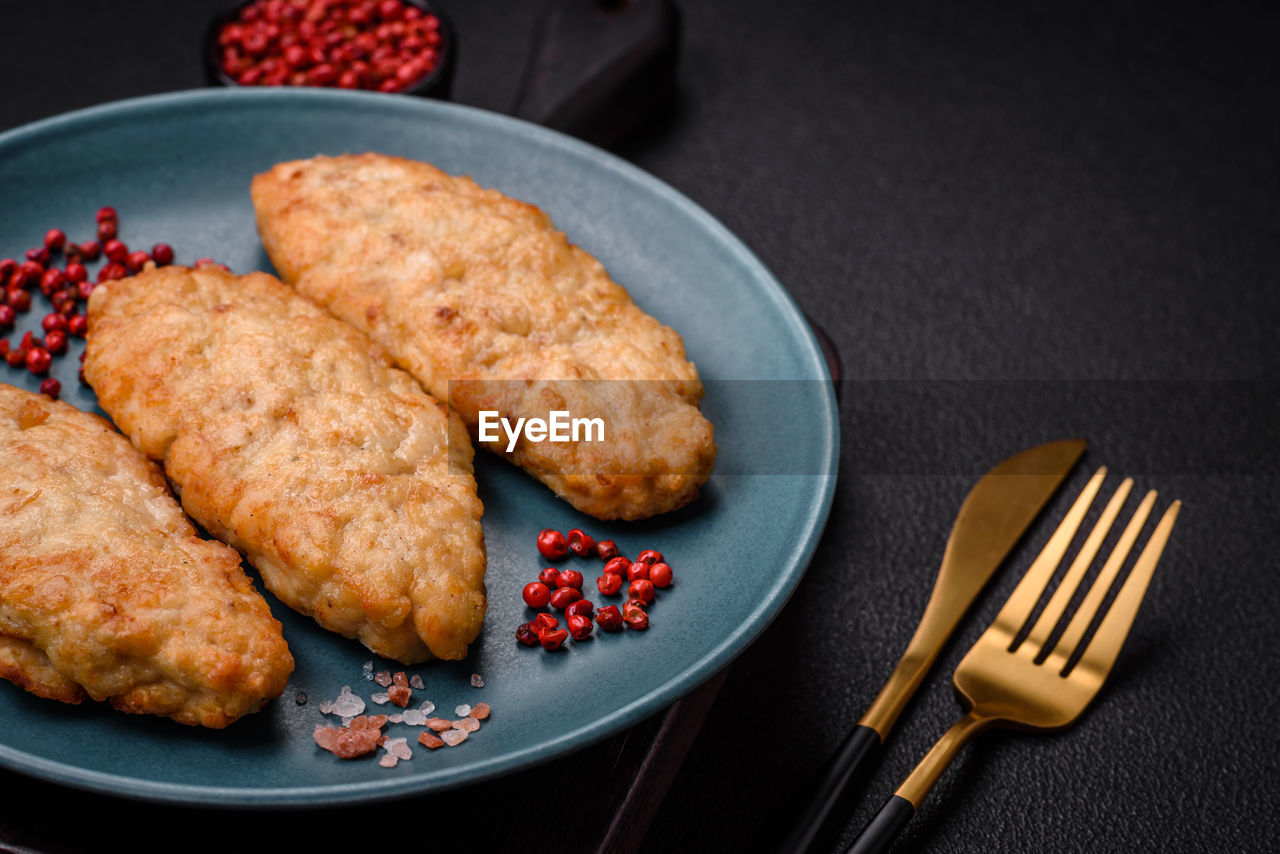 food and drink, food, meat, fast food, dish, studio shot, freshness, plate, no people, fried food, fork, meal, indoors, healthy eating, kitchen utensil, eating utensil, fried, fruit, black background, produce, breakfast, household equipment, dinner, fish, close-up, wellbeing, cuisine