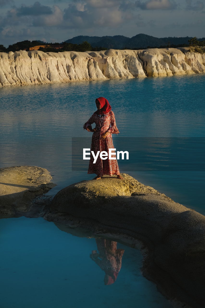 Woman standing on rock by lake