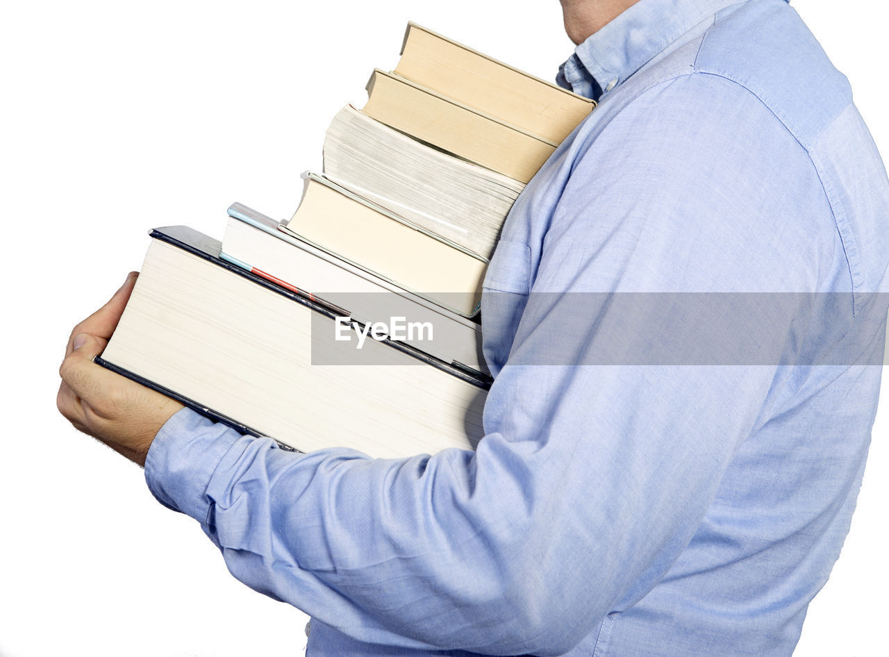 Midsection of man carrying books against white background