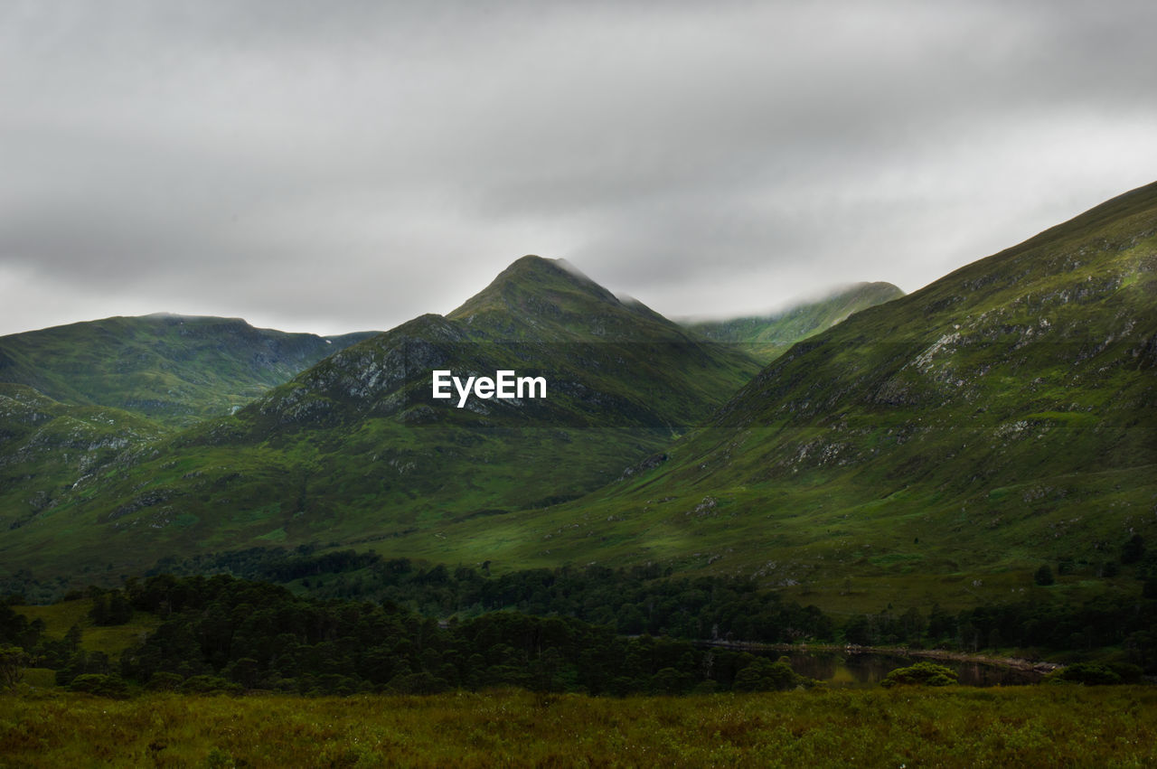 Scenic view of field and mountains against sky