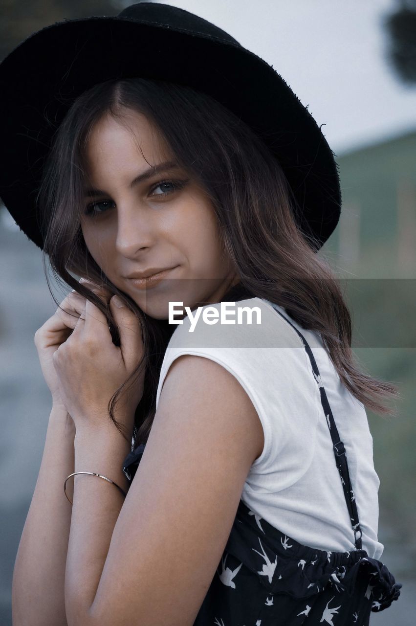 Portrait of young woman wearing hat outdoors