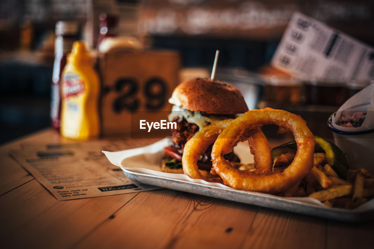 Close-up of burger and onion rings on table