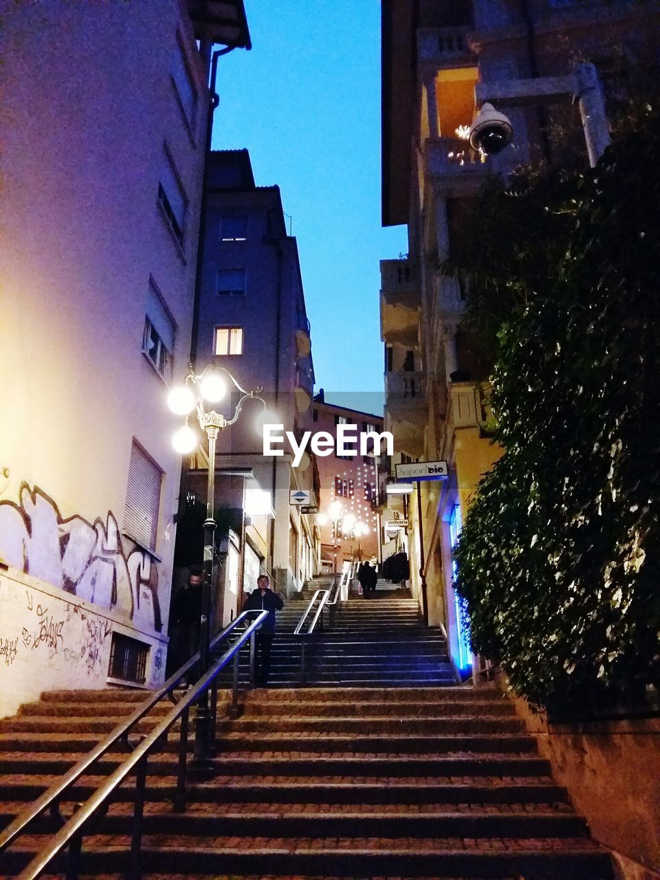 Low angle view of steps amidst buildings at dusk