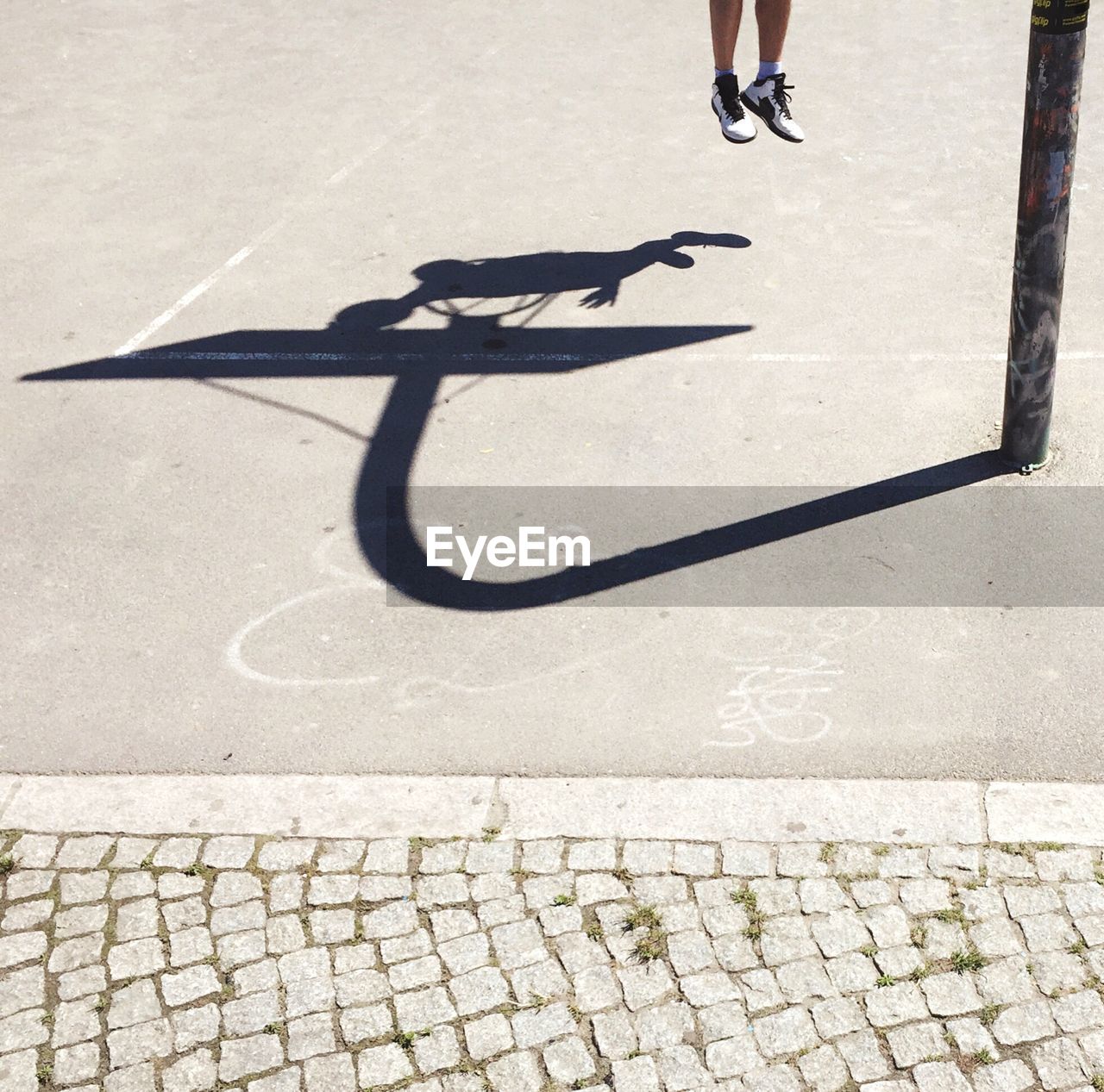 Shadow of man playing basketball on court