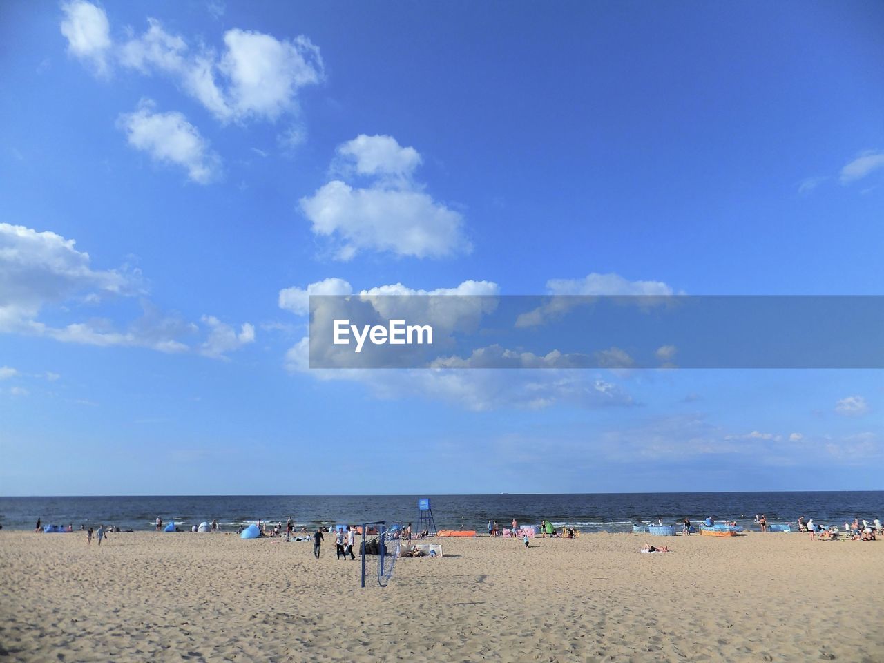 People on beach against blue sky