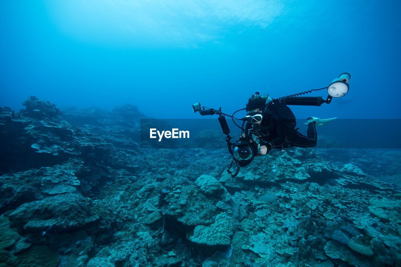 HIGH ANGLE VIEW OF MOTORCYCLE ON SEA