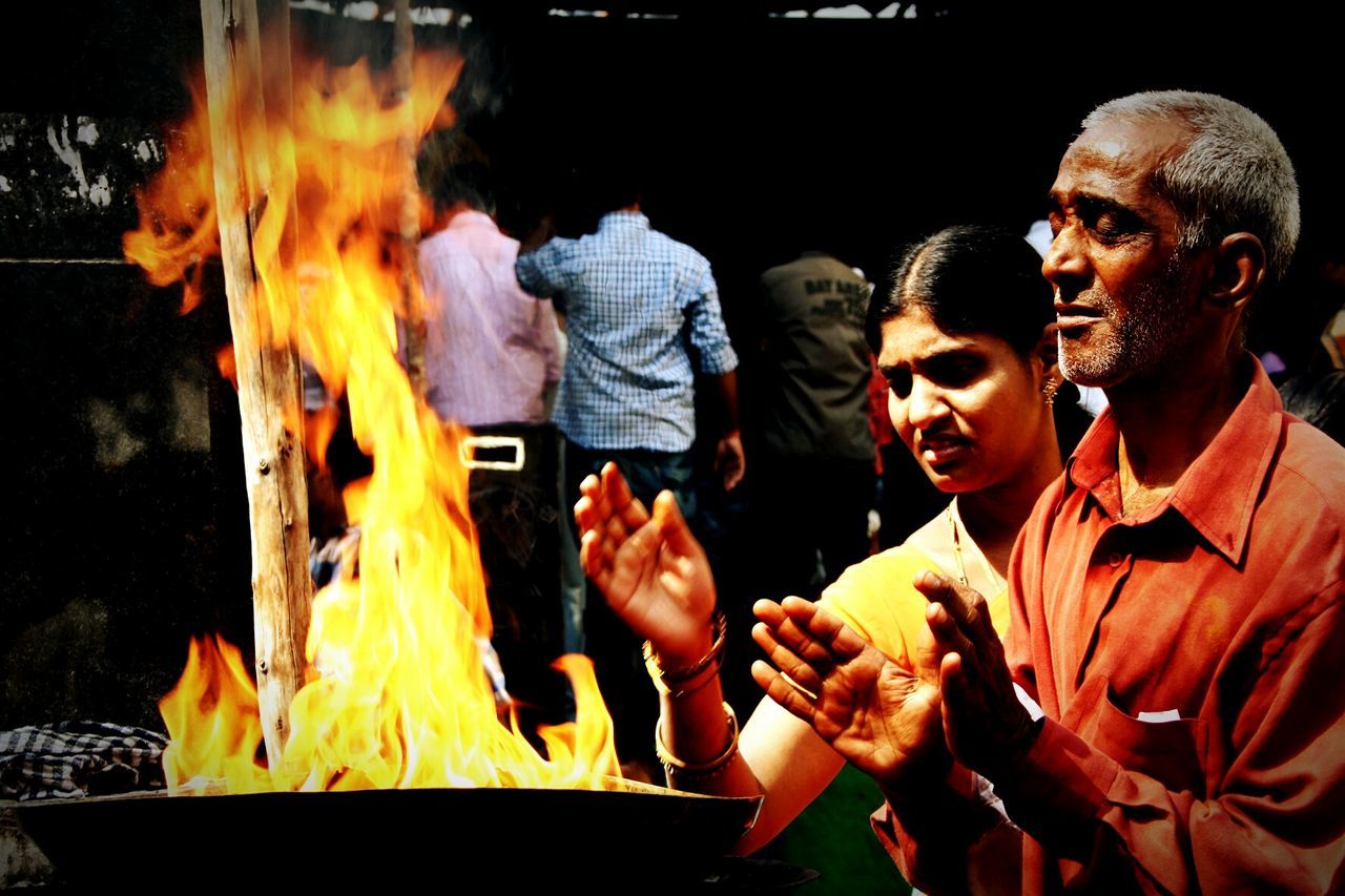 Man and woman standing by fire pit