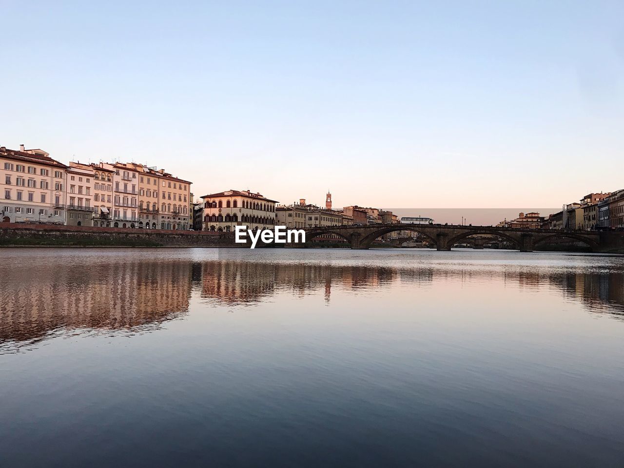 REFLECTION OF BUILDINGS IN CITY AT SUNSET